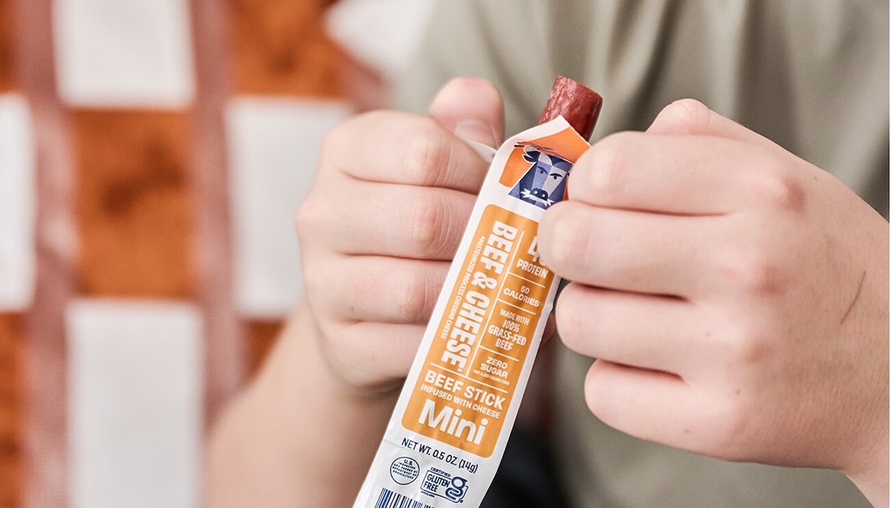 child opening an Archer Beef and Cheese Mini Stick